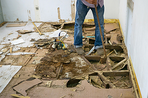 person stood on damaged attic floor