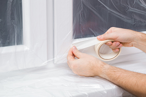 a man seals up attic doors after learning how to get rid of mold in the attic
